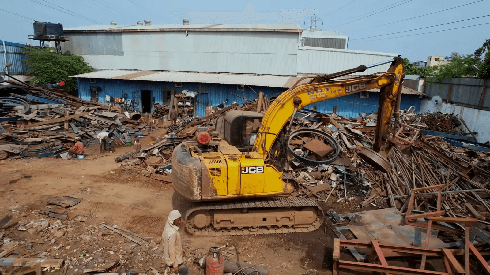 JCB excavator with magnetic attachment on a scrap yard